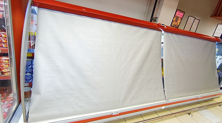 Night blinds fitted on open display chiller in modern convenience store