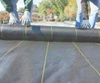 Flat lay detail of high tensile black geotextile with construction marking lines, tear-resistant road base separation fabric