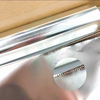 Hand tearing aluminum foil, highlighting easy tear and convenient handling features.