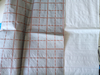 Folded flat shot of red grid printed PP woven cloth, grid reinforcement boosts tensile strength for floor & roof underlay