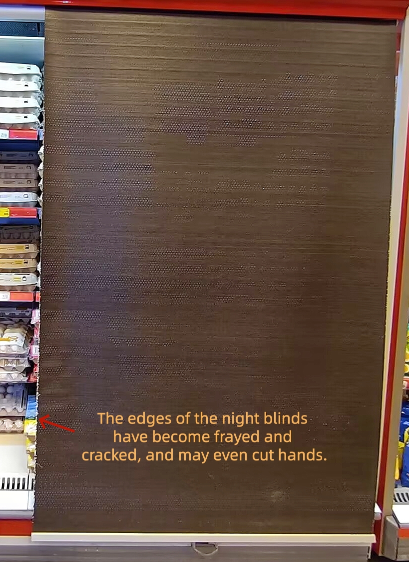Low-quality supermarket freezer night blind with frayed cracked edges, sharp fringes cause staff hand lacerations