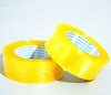 Two wide bright yellow clear tape rolls diagonal shot, wider surface speeds up cross-border & large logistics carton sealing