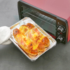 Close-up of golden roasted food in square aluminum foil pans, showing practical cooking results
